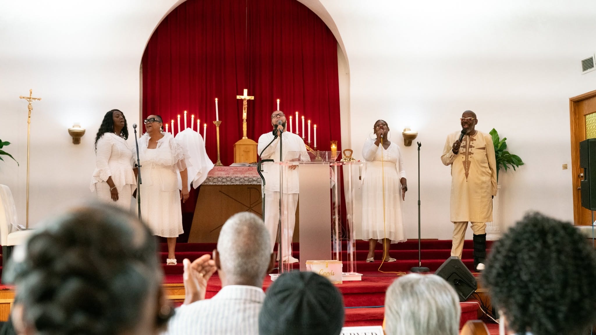 Voices lifted in white — the praise team leads the house