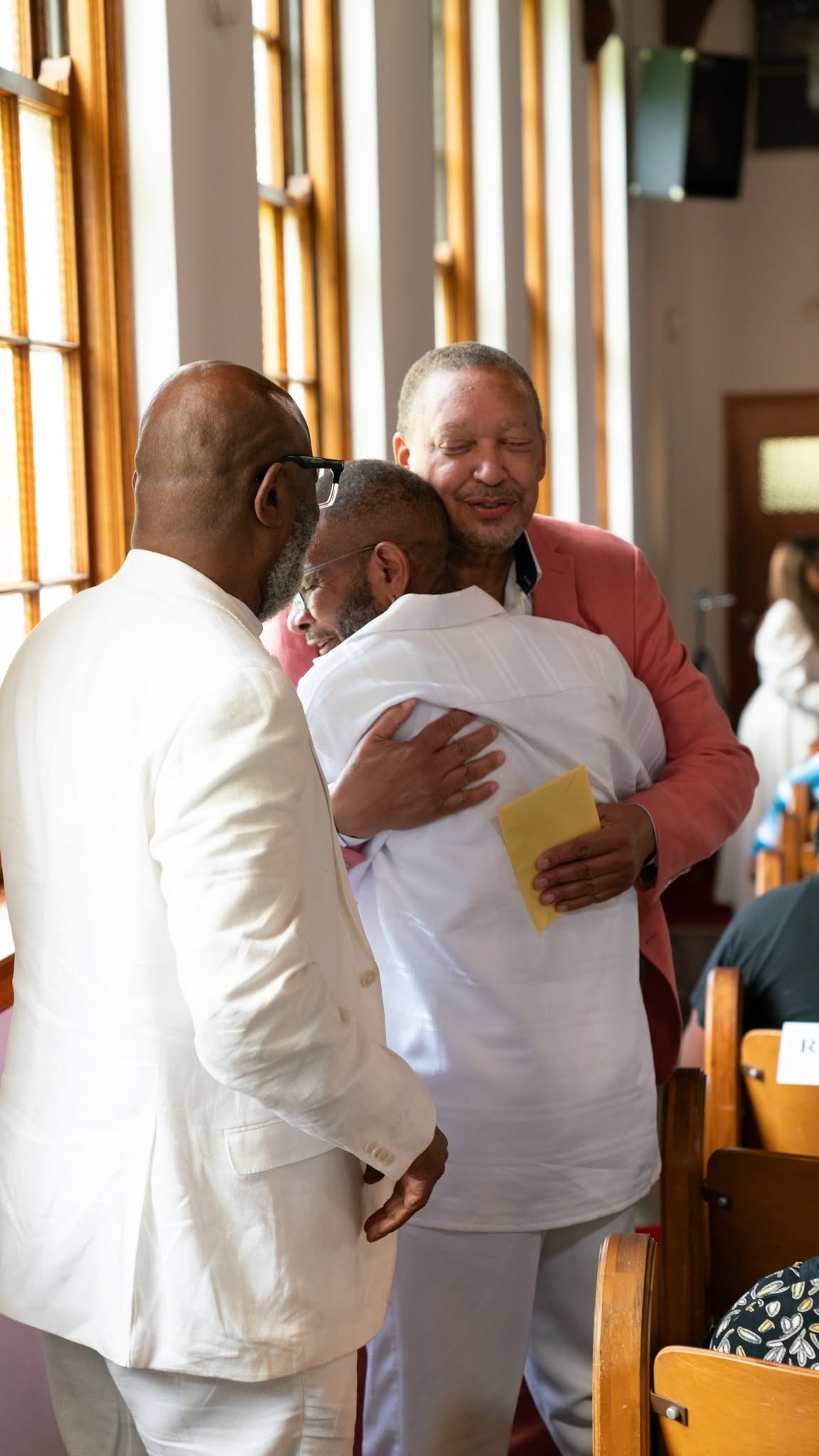 Three brothers embrace — love and fellowship in the sanctuary