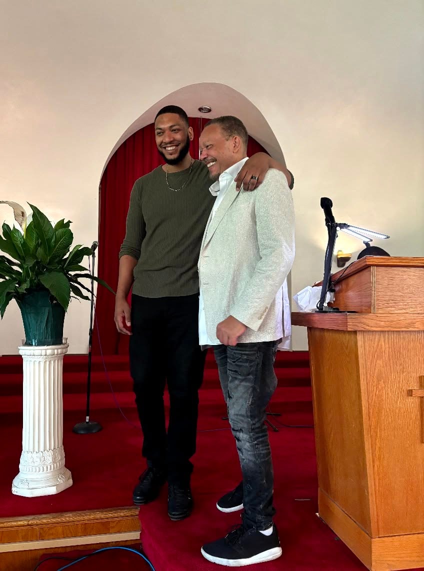 Brothers in the Lord — two men share a joyful moment at the altar